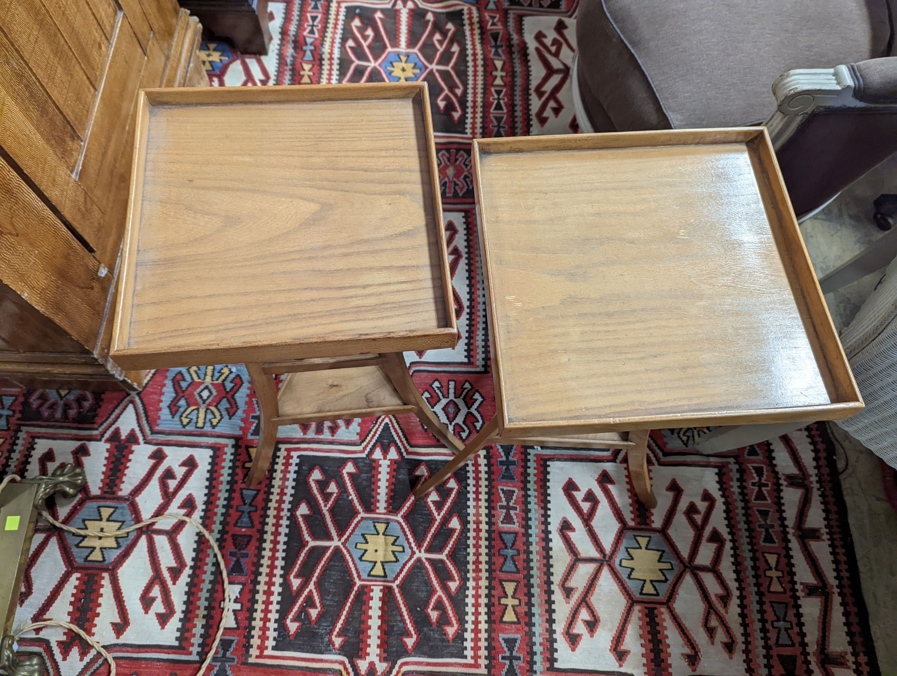 A pair of 1950's French design fruitwood square top three tier occasional tables, width 31cm, height 68cm